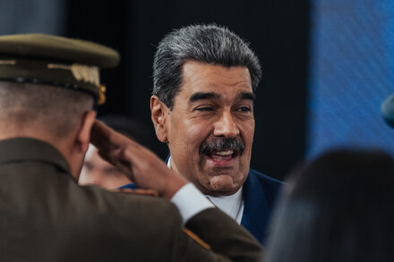Venezuelan President Nicolás Maduro gestures during a press conference in Caracas, with a Venezuelan flag behind him. He appears defiant.
