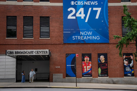 Paramount logo and The Free Press logo side-by-side, symbolizing the acquisition, with a CBS News microphone visible in the foreground.