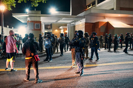 Federal officers stand guard outside a courthouse in Portland during protests