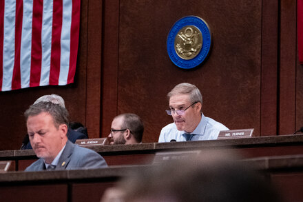 A group of Republican politicians reviewing documents related to college tuition costs, symbolizing an investigation into firms that influence these prices.