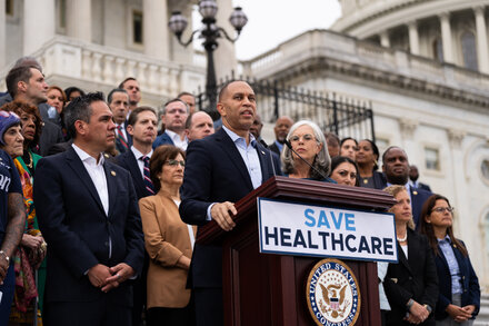 Two prominent politicians, one Republican and one Democrat, stand in front of the U.S. Capitol building, pointing fingers at each other with serious expressions, symbolizing the partisan gridlock as a government shutdown approaches.