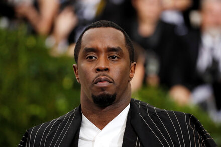 Sean 'Diddy' Combs sits in a courtroom, looking pensive as a judge delivers a ruling. He is wearing a dark suit.