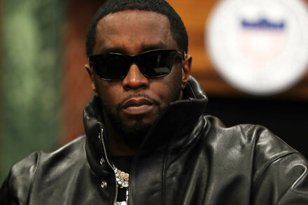Un montaje de fotos muestra a Sean 'Diddy' Combs en diferentes poses. A la izquierda, una foto de perfil de un archivo policial con él en una camiseta blanca. A la derecha, un primer plano de su rostro con un ojo semicerrado. En el centro, una foto de cuerpo completo de él en un tribunal, vistiendo un traje oscuro y corbata, con las manos esposadas y un semblante serio.