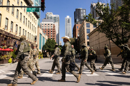 Federal agents in tactical gear with vehicles on a street in Chicago, illustrating an ICE crackdown.