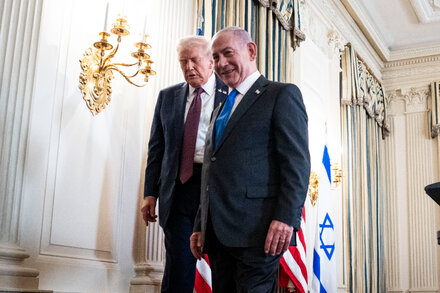 Donald Trump and Benjamin Netanyahu addressing reporters, standing at podiums with flags behind them.