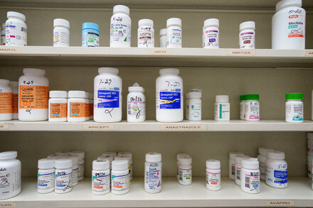 Donald Trump holding a bottle of pills with an online drugstore interface in the background, symbolizing his new venture and its potential impact on drug costs.